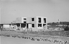 Two-story home under construction. Note water tower. (photo: Russell Lee)